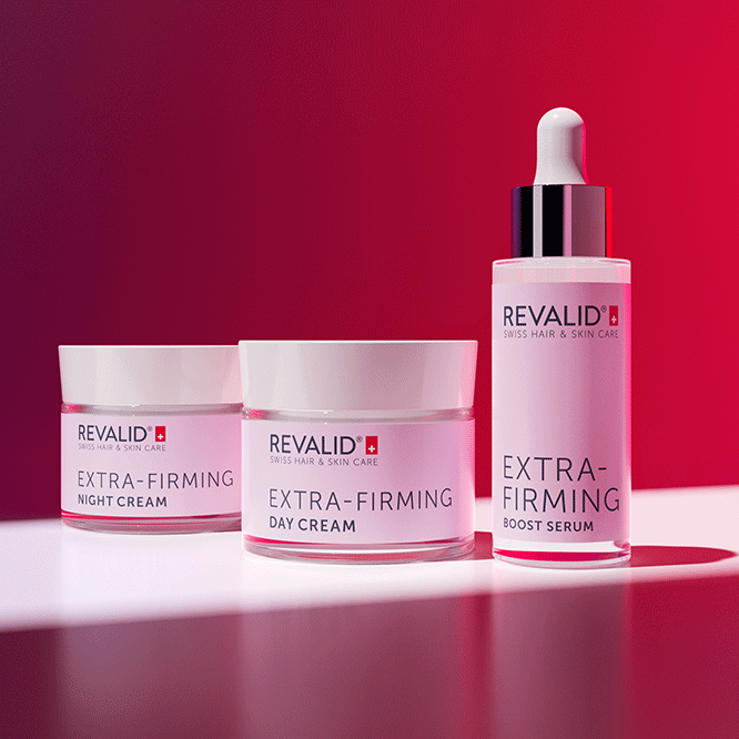 Revalid Extra-Firming Night Cream, Day Cream, and Boost Serum displayed on a white surface against a vibrant red backdrop.